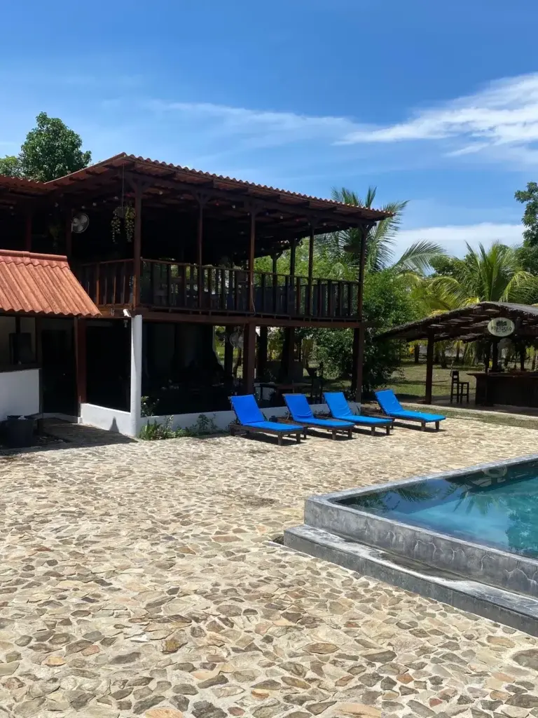 Two-storey hardwood lodge with blue loungers on the stone pool deck