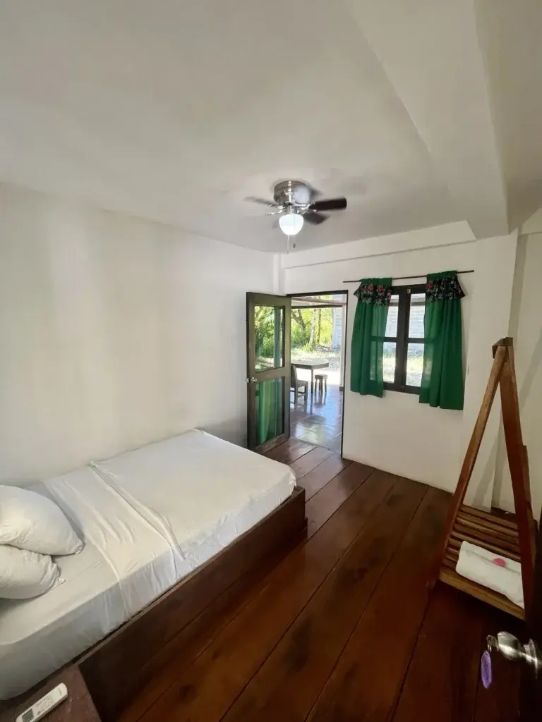 Villa bedroom with hardwood floors and a door to the garden