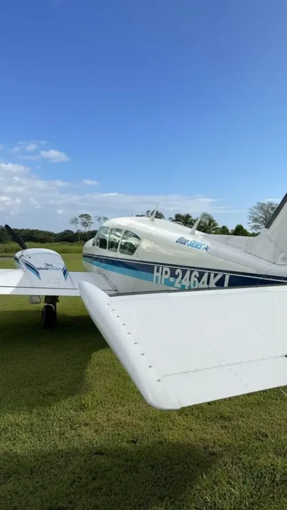 Avioneta chárter bimotor de Blue Skies estacionada sobre el césped en Lago Bay