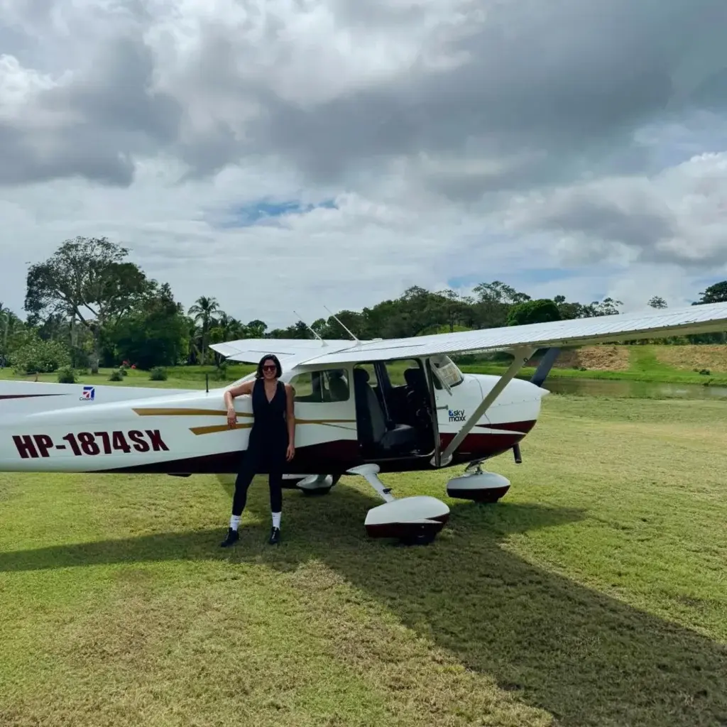 Pasajero junto a un Cessna estacionado en la pista de césped de Lago Bay