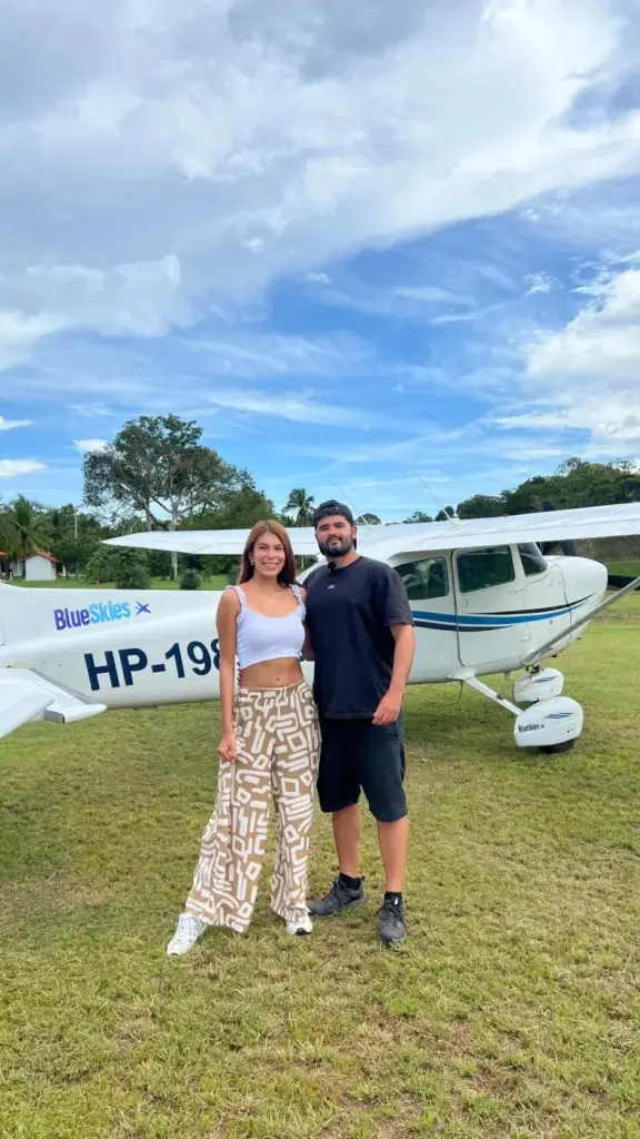 Pareja junto a un Cessna de Blue Skies en la pista de césped de Lago Bay, Santa Catalina