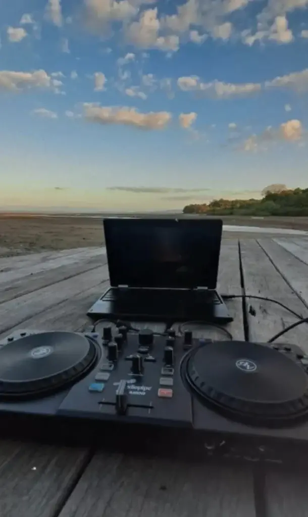 DJ decks set up on the deck at sunset over the Pacific