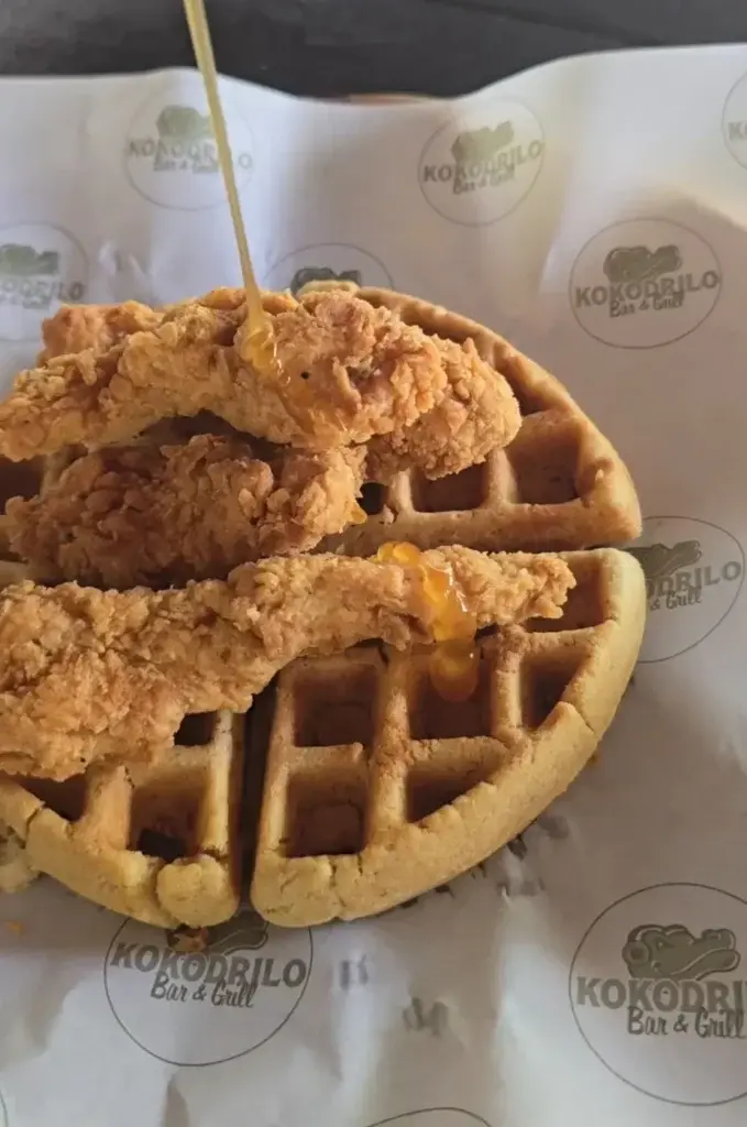 Fried chicken and waffles drizzled with honey at Kokodrilo Bar & Grill