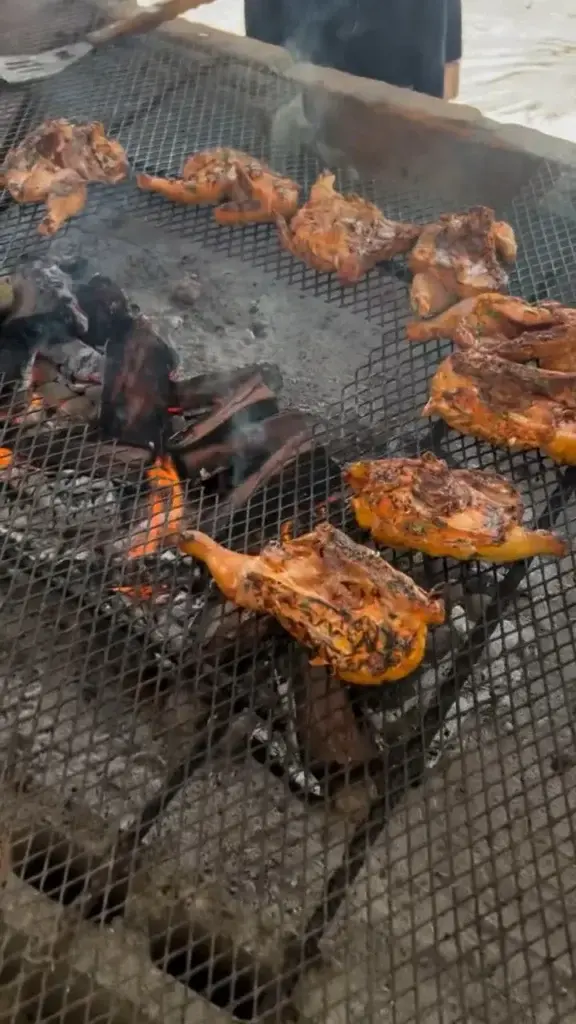 Chicken cooking over an open fire on the grill