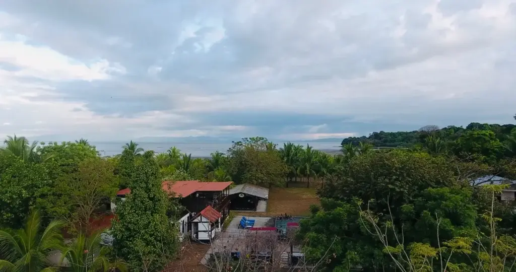 Aerial view of the Bliss Beach lodge, pool and gardens with the Pacific behind