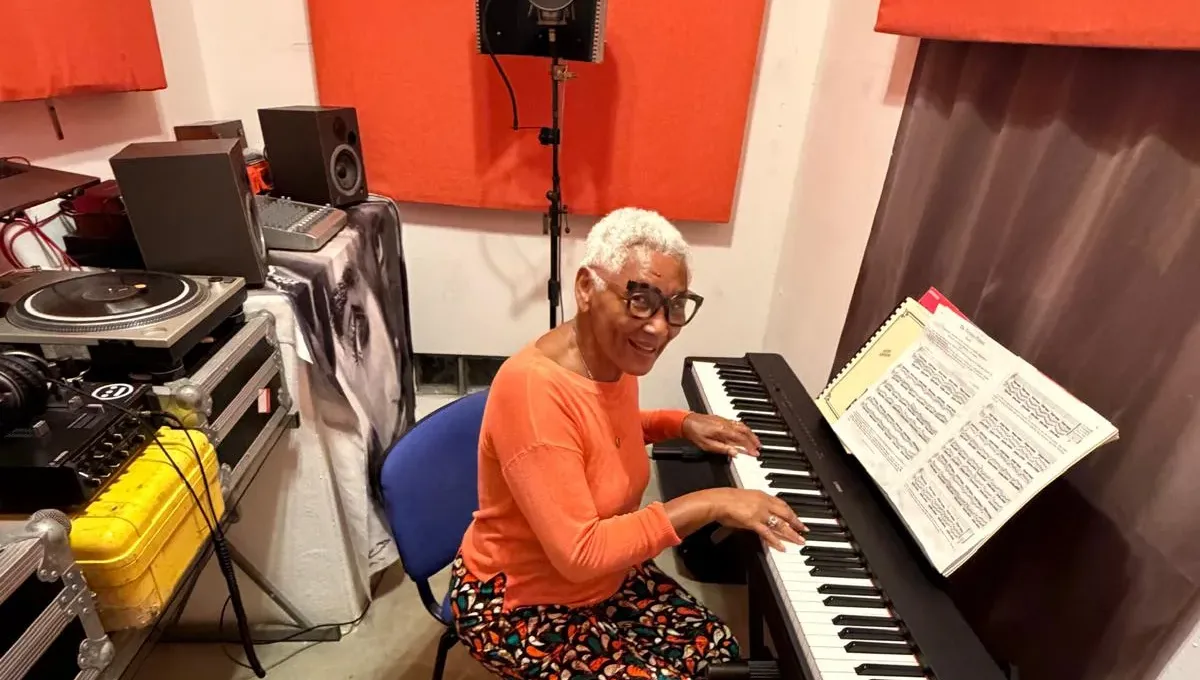 Guest playing a keyboard in the Bliss Beats recording studio, with turntables and studio monitors beside her