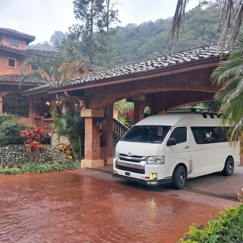 Van de shuttle estacionada en la entrada de un hotel en la montaña