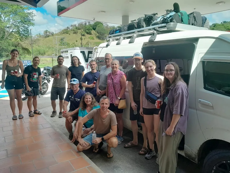 Grupo de viajeros junto a su van de shuttle con equipaje en el techo