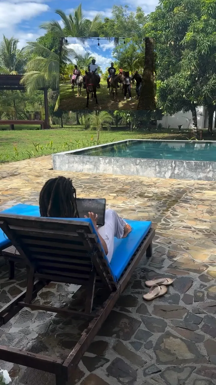 Resident working on a laptop from a poolside lounger