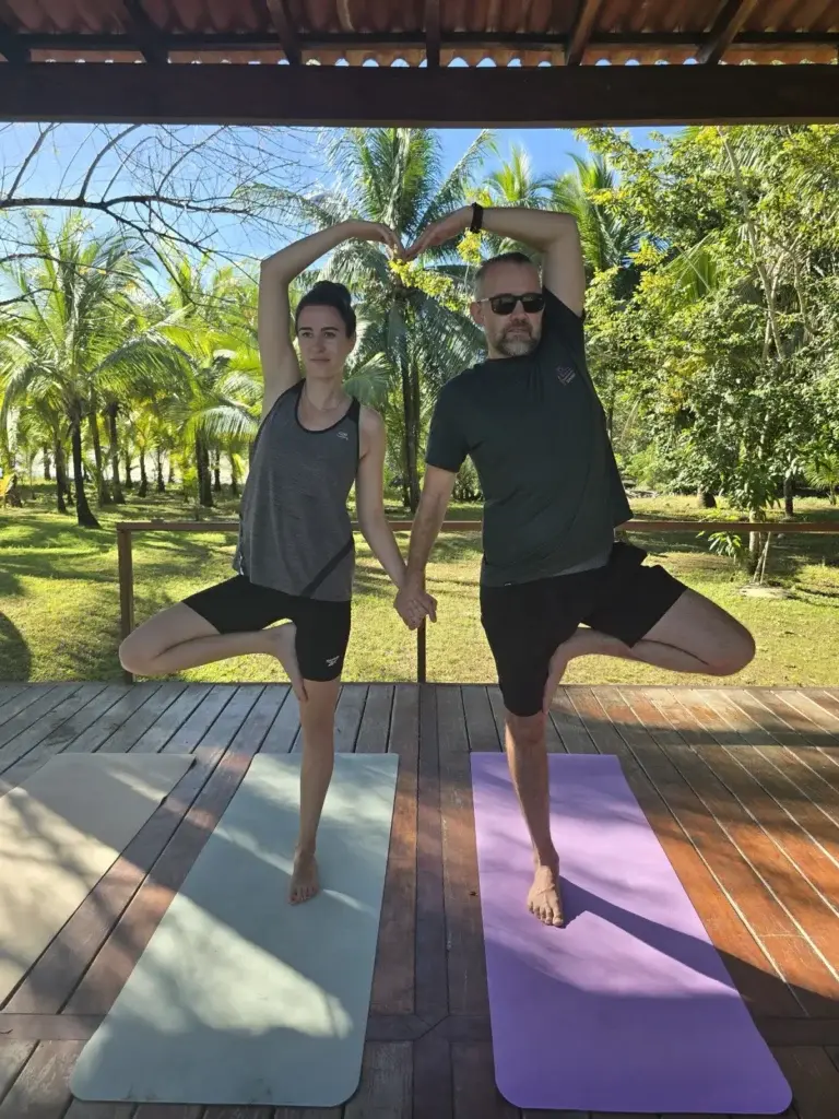 Two guests in partner tree pose on the yoga deck